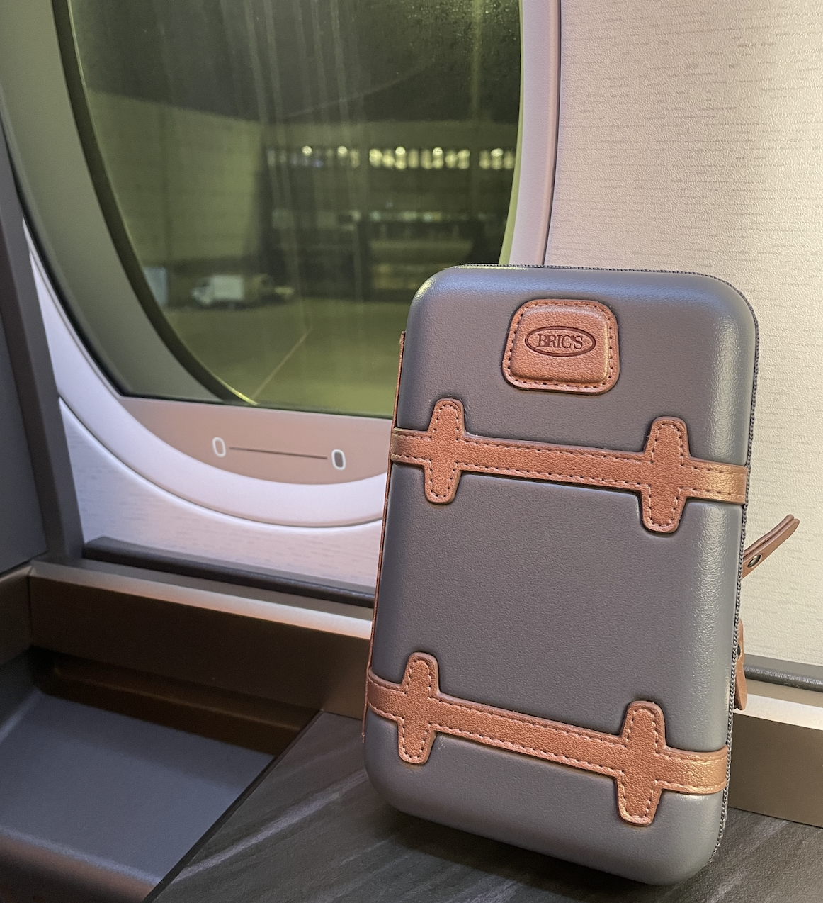 a grey and brown suitcase on a window sill